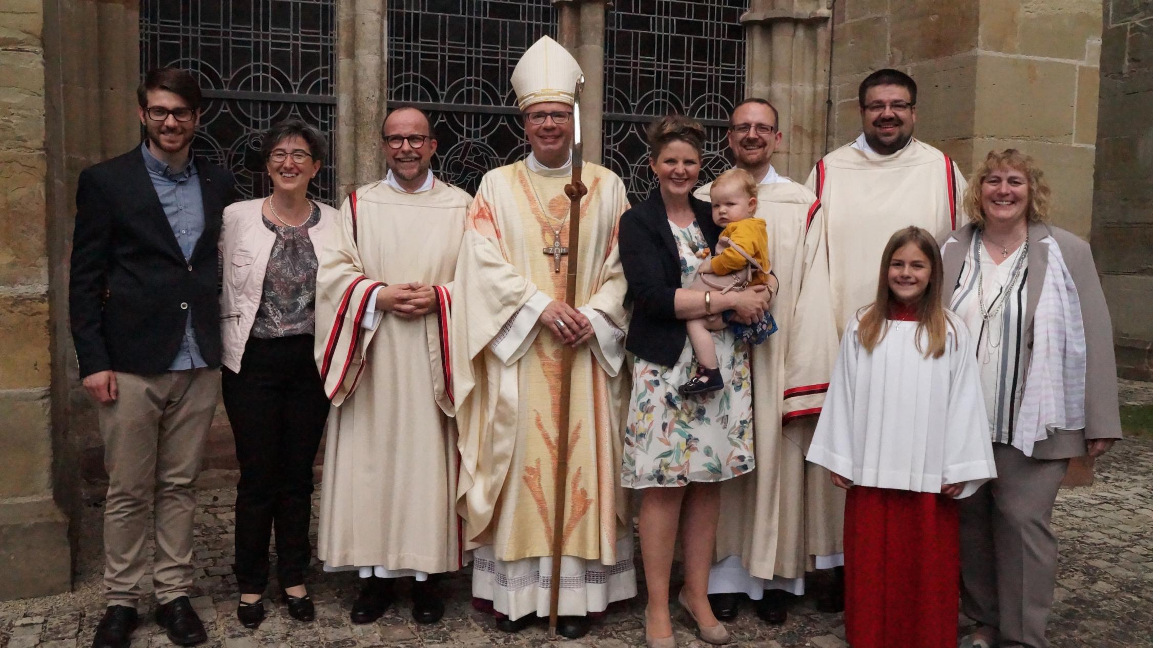 Mit ihren Familien und Bischof Stephan Ackermann freuen sich die neugeweihten ständigen Diakone Peter Kurtscheid, Sebastian Zinken und Michael Stephan (von links).