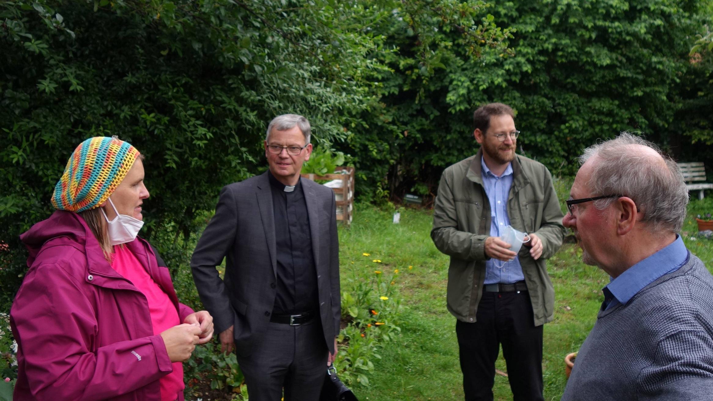 Die Ehrenamtliche Tina Monzen, Dechantenkooperator Oliver Seis (Zweiter v. rechts) und Josef Freise vom Koordinationsteam (rechts) zeigen dem Generalvikar (Zweiter v. links) die Gärten rund um Heilig Kreuz. Foto: Julia Fröder